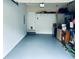Clean, spacious garage featuring a sealed floor, ample storage space, and a convenient access door at 9030 Brockham Way, Johns Creek, GA 30022