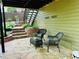 Cozy patio seating area featuring stone flooring, lush garden beds, and easy access to an upper deck at 9030 Brockham Way, Johns Creek, GA 30022