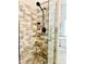 Modern shower featuring stylish stone tile, matte black hardware, and a glass enclosure at 9030 Brockham Way, Johns Creek, GA 30022