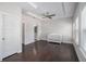 Bright bedroom featuring hardwood floors, modern ceiling fan, tray ceilings, and a white crib at 2026 Manchester Ne St, Atlanta, GA 30324