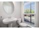 Chic powder room with pedestal sink, modern faucet, and large window with blinds at 2026 Manchester Ne St, Atlanta, GA 30324
