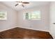 Light-filled bedroom with hardwood floors, ceiling fan and two windows at 2999 San Juan Dr, Decatur, GA 30032