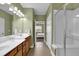 Ensuite bathroom with dual sink vanity, a walk-in shower, and neutral tiling at 241 Orchards Cir, Woodstock, GA 30188