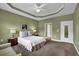 Spacious bedroom with tray ceilings, neutral walls, carpet flooring, and access to the ensuite bath at 241 Orchards Cir, Woodstock, GA 30188