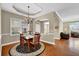 Well-lit dining area with wood table, chandelier, and adjacent living space, great for gatherings at 241 Orchards Cir, Woodstock, GA 30188