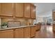 Cozy kitchen space with wood cabinets, granite countertop, and a view of the living area at 241 Orchards Cir, Woodstock, GA 30188