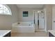Bright bathroom with a soaking tub, separate shower, and a decorative window at 3743 Southland Dr, Buford, GA 30519