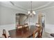 Elegant dining room features a dark wood table, decorative wainscoting, and a stylish chandelier at 3743 Southland Dr, Buford, GA 30519