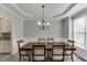 Elegant dining room featuring a decorative chandelier, large window, and wainscoting with seating for six at 3743 Southland Dr, Buford, GA 30519