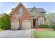 Charming two-story brick home with a well-manicured lawn and a basketball hoop over the two-car garage at 3743 Southland Dr, Buford, GA 30519
