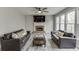 Spacious living room with a brick fireplace, ceiling fan, large windows, and comfortable sofas for entertaining at 3743 Southland Dr, Buford, GA 30519