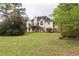 Large backyard featuring mature trees and a deck with stairs to the lower level at 703 Paul Revere Dr, Locust Grove, GA 30248