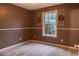 Cozy bedroom featuring neutral carpet, a window, and unique decorative shutters adding a touch of rustic charm at 703 Paul Revere Dr, Locust Grove, GA 30248