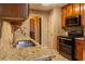 Kitchen featuring granite counters, black appliances, tile backsplash and wood cabinetry at 703 Paul Revere Dr, Locust Grove, GA 30248
