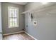 Laundry room with grey walls, wood-look tile floor and shelving, offering functionality with style at 703 Paul Revere Dr, Locust Grove, GA 30248