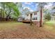 Wide-angle view of a home's backyard featuring a cozy deck and lush greenery at 1196 Oak Sw Rd, Lilburn, GA 30047