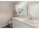 Neutral bathroom features a white vanity with storage and a view from the window at 1196 Oak Sw Rd, Lilburn, GA 30047
