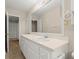 Bright bathroom features a white vanity with storage and a large mirror at 1196 Oak Sw Rd, Lilburn, GA 30047