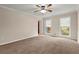 Bright bedroom with neutral carpet, ceiling fan, and double windows with natural light at 1196 Oak Sw Rd, Lilburn, GA 30047