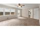 Carpeted bedroom with ceiling fan, bright windows, and access to the backyard and kitchen at 1196 Oak Sw Rd, Lilburn, GA 30047