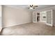 Spacious living room featuring neutral carpet, ceiling fan, and French doors leading to an adjacent room at 1196 Oak Sw Rd, Lilburn, GA 30047