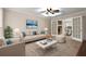 Inviting living room with ceiling fan, stylish furniture, and elegant French doors to dining area at 1196 Oak Sw Rd, Lilburn, GA 30047