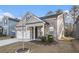 View of the home featuring a brick and siding exterior, two-car garage, and manicured lawn at 345 Caledonia Ct, Peachtree City, GA 30269
