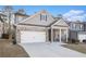 Charming single Gathering home featuring a brick and siding exterior, manicured lawn, and two-car garage at 345 Caledonia Ct, Peachtree City, GA 30269