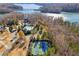 Aerial view of lakeside community with pool, tennis courts, and stunning lake views at 5705 Windjammer Pt, Cumming, GA 30041