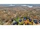 Aerial view of homes in a neighborhood surrounded by trees near a lake at 5705 Windjammer Pt, Cumming, GA 30041