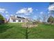 Scenic backyard with a lush green lawn, solar panels on roof, and garden with an arbor at 5705 Windjammer Pt, Cumming, GA 30041