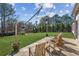 Relaxing backyard with a concrete patio, wooden chairs, string lights, and a lush green lawn at 5705 Windjammer Pt, Cumming, GA 30041