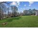 Spacious backyard with a lush green lawn, mature trees, and a view of the surrounding landscape at 5705 Windjammer Pt, Cumming, GA 30041