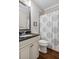 Cozy bathroom featuring vanity with dark counters and patterned shower curtain at 5705 Windjammer Pt, Cumming, GA 30041