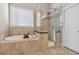 Bathroom featuring glass shower, tub, tile floor, and window at 5705 Windjammer Pt, Cumming, GA 30041