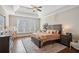 Comfortable bedroom featuring tray ceiling, ceiling fan, window, and carpet at 5705 Windjammer Pt, Cumming, GA 30041
