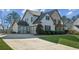 Beautiful home exterior featuring a three-car garage and large driveway at 5705 Windjammer Pt, Cumming, GA 30041