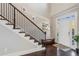 Elegant foyer with hardwood floors, staircase, and ample natural light through the front door at 5705 Windjammer Pt, Cumming, GA 30041