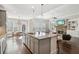 Spacious kitchen with island seating, seamlessly connected to living room with fireplace at 5705 Windjammer Pt, Cumming, GA 30041