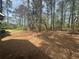 Shaded backyard featuring mature trees and an old outbuilding that offers potential for a workshop or storage shed at 5834 Heardsville Rd, Cumming, GA 30028