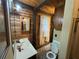 Cozy bathroom features wood paneled walls, a vanity, and well-lit mirror providing a charming, rustic atmosphere at 5834 Heardsville Rd, Cumming, GA 30028