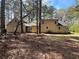Home exterior surrounded by mature trees and partial driveway surrounded by pine needle ground covering at 5834 Heardsville Rd, Cumming, GA 30028