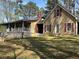 Charming home with a welcoming porch, brick chimney, and red shutters nestled among mature trees at 5834 Heardsville Rd, Cumming, GA 30028