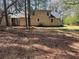 Home exterior with mature trees and partial driveway surrounded by pine needle ground covering at 5834 Heardsville Rd, Cumming, GA 30028