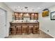 Basement wet bar with granite counter, stools, and storage cabinets at 611 Vinings Estates Se Dr, Smyrna, GA 30126