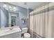 Light blue bathroom featuring white fixtures, including a vanity, toilet, and patterned shower curtain at 611 Vinings Estates Se Dr, Smyrna, GA 30126