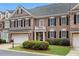 Charming brick townhome featuring an attached garage, black shutters, and manicured landscaping in a desirable community at 611 Vinings Estates Se Dr, Smyrna, GA 30126
