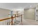 A spacious upper landing with wood railings, carpet, and an open view to a dining room with chandelier at 611 Vinings Estates Se Dr, Smyrna, GA 30126