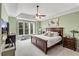 Spacious main bedroom features a tray ceiling, large windows, and dark furniture at 611 Vinings Estates Se Dr, Smyrna, GA 30126