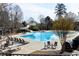 Resort-style pool area featuring a slide, ample seating, and mature trees at 611 Vinings Estates Se Dr, Smyrna, GA 30126